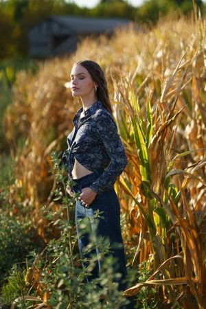 A Serene Young Woman in a Beautiful Cornfield Happily Embracing the Natural Beauty Around Her