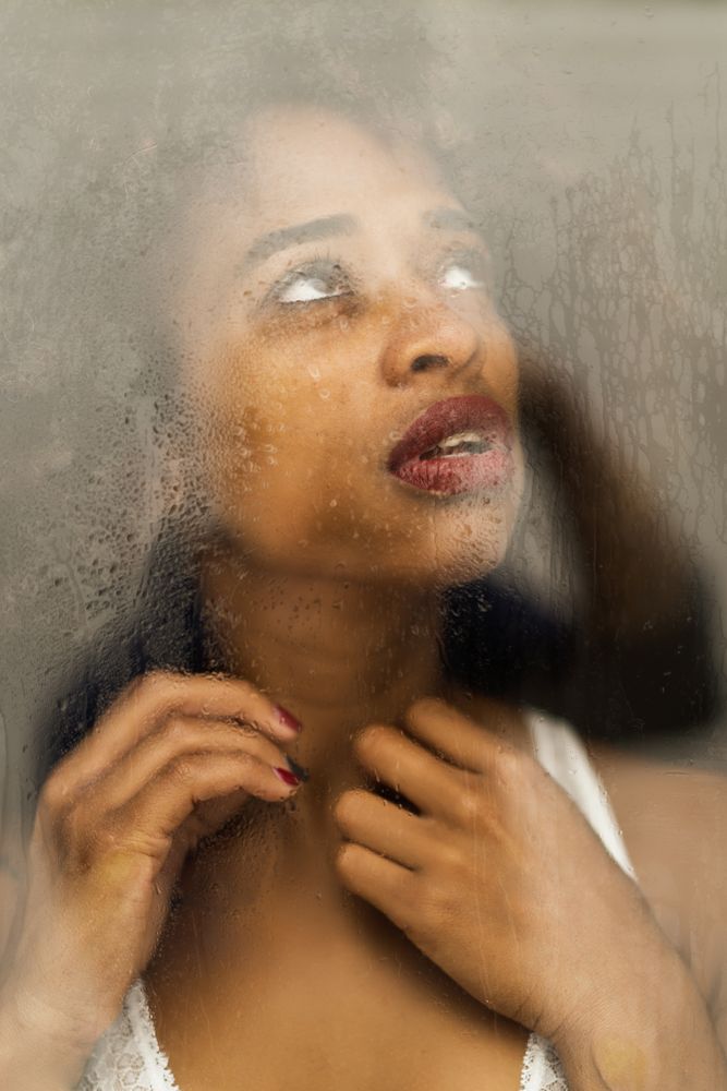 Black woman behind wet glass