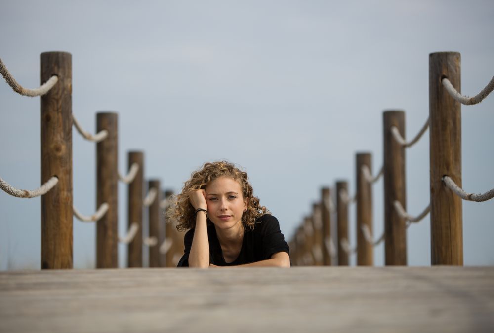 Young woman sitting on footbridge