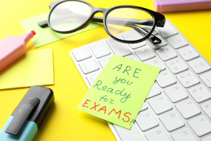 Post it note of “are you ready for exams” on computer keyboard with stationary