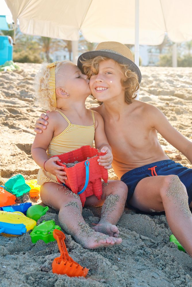 Happy little boy and girl on beach in summer