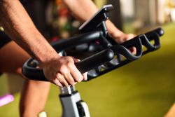 Hands of a man training at a gym doing indoor biking