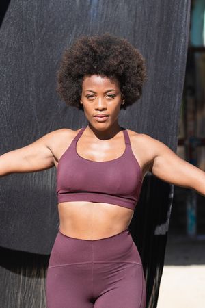Fit Black woman with hammock for yoga in city