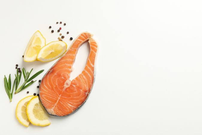 Composition with salmon meat and spices on plain background, top view