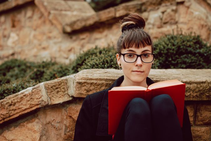 Young woman reading book on steps