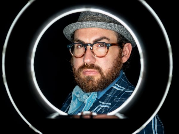 Stylish man in elegant suit behind special circle light