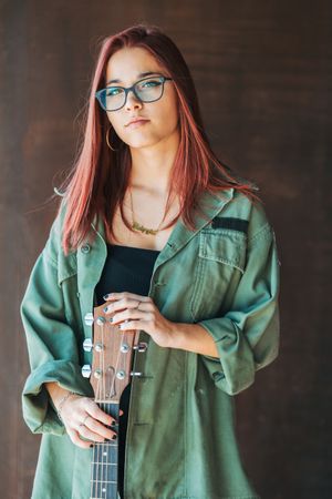 Woman in glasses leaning on wall