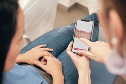 Female dentist showing 3D picture of patient teeth during appointment