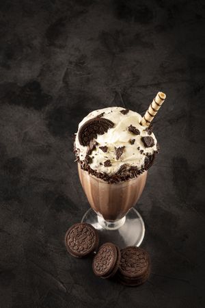Chocolate milkshake with pieces of chocolate chip cookies.