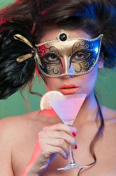 Woman in mask holding glass of drink