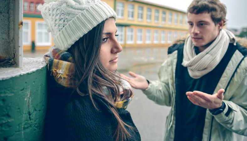 Couple in winter clothes having an argument outside
