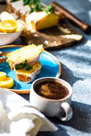 Coffee served with delicious lemon cake with fresh mint garnish