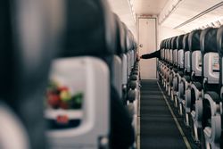 Unrecognizable hand reaching across a row in a plane