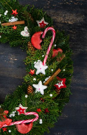 Top view of Christmas wreath with candy cane, cinnamon and stars, vertical composition