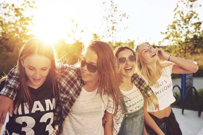 Group of female teenagers walking together and smiling in the sun