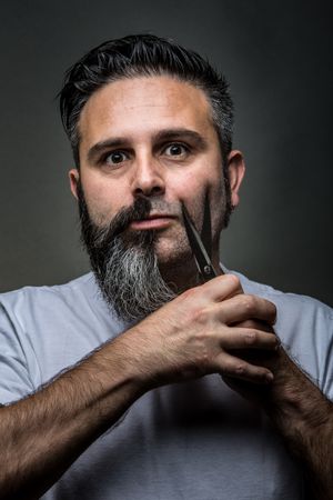 Expressive barber cutting beard