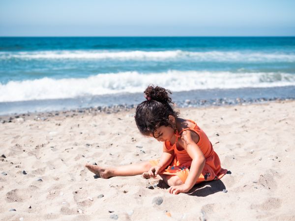 Little girl sitting on beach