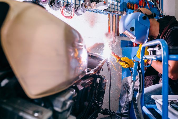 Motorcycle mechanic welding in the workshop