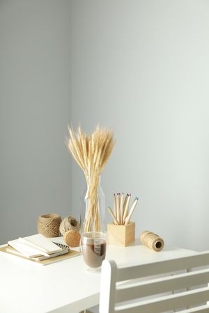 Work table with yarn, notebooks, pencils and chair, vertical