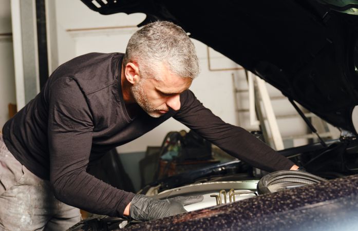 Mechanic fixing car engine in garage