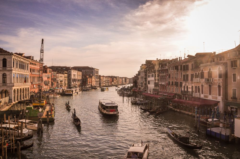 Boats on body of water between buildings in Venice, Italy 