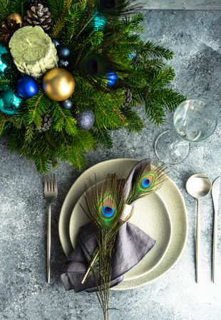 Top view of elegant festive table setting for Christmas dinner with peacock feathers