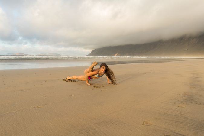Woman doing handstand near sea