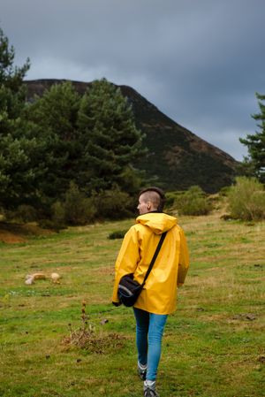 Person in yellow raincoat walking in forest
