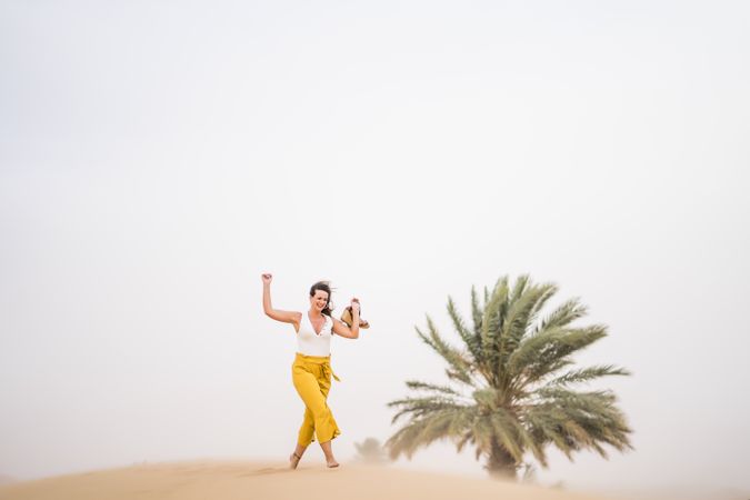 Happy woman dancing in desert