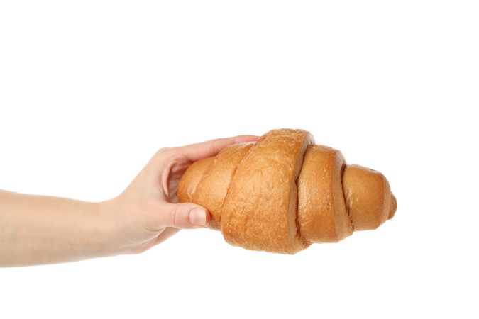 Female hand holding croissant, isolated on plain background