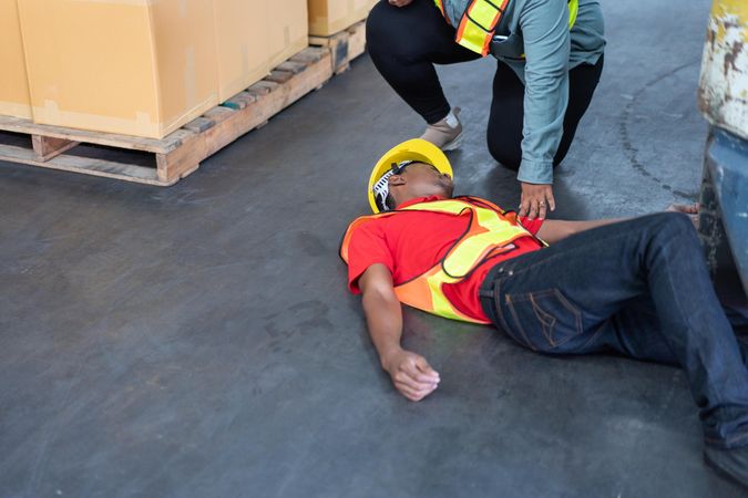 Black male in PPE gear passed out on warehouse floor