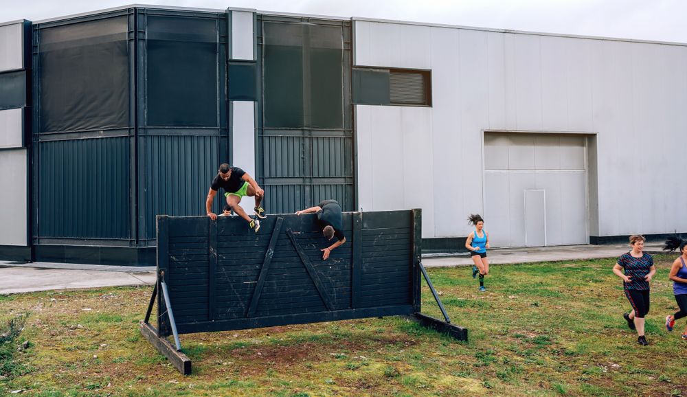 Participants in obstacle course running and climbing wall
