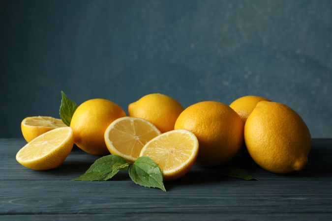 Fresh lemons and leaves on wooden table. Ripe fruit
