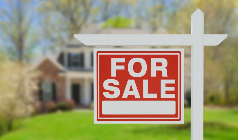 For Sale Real Estate Sign in Front of Beautiful House.