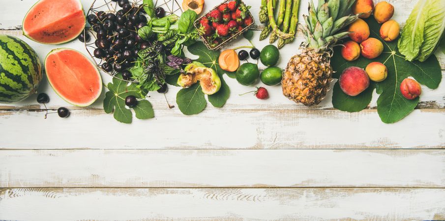 Summer fruits of watermelon halves, cherries, figs, strawberry on wood, with copy space