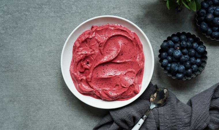 Smoothy of fresh bog blueberries and raspberries in bowl near napkin