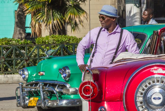 Havana, Cuba - November, 22 2012: Black man near retro cars on street