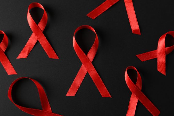 Awareness red ribbons on dark background, close up