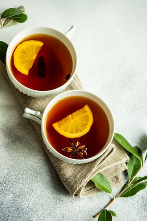 Two tea cups with lemon and star anise