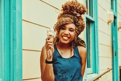 Happy Black female smiling with an ice cream cone in the sun