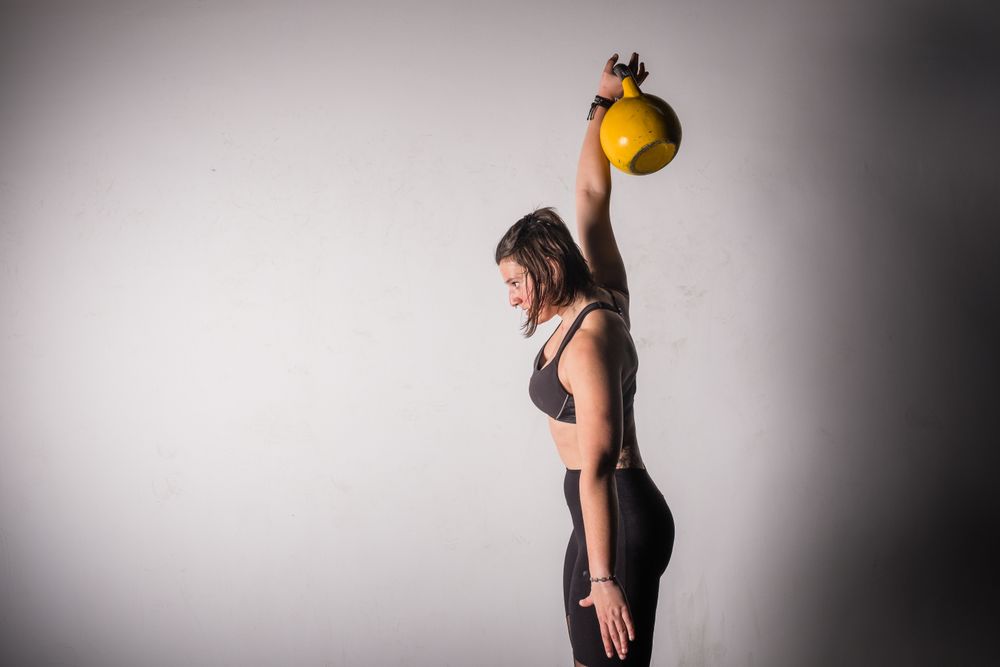 woman lifting kettlebell in gym
