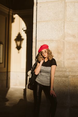 Stylish female standing near building wall