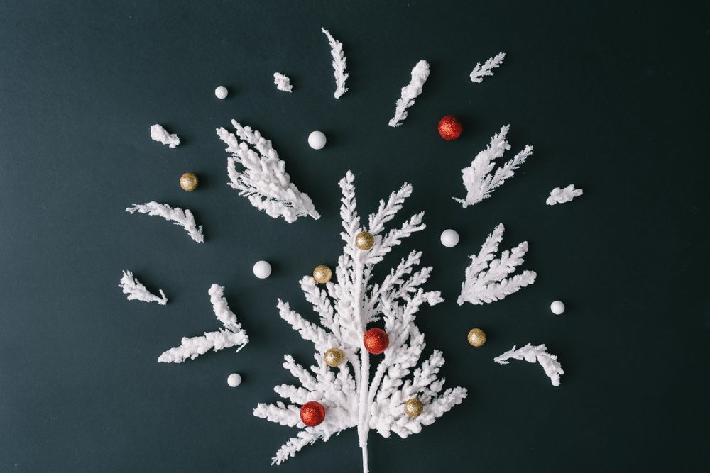Christmas tree branches in tree shape with bauble decorations on dark table background