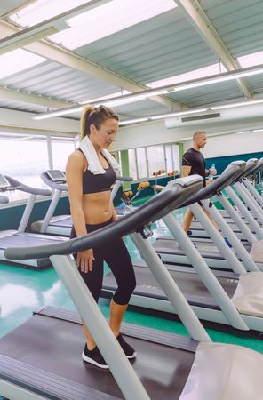 Row on treadmills in gym with people working out