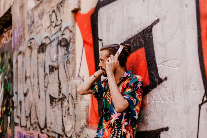 Smiling man listening to music and using smartphone