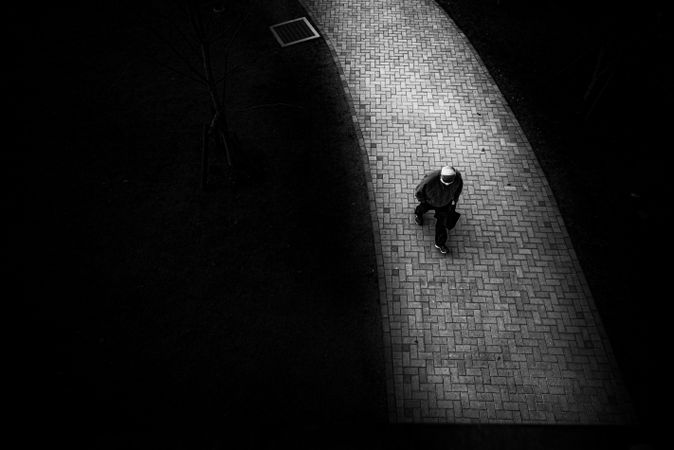 Top view of person walking on pathway in grayscale