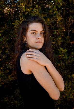 Sporty girl standing in bush background