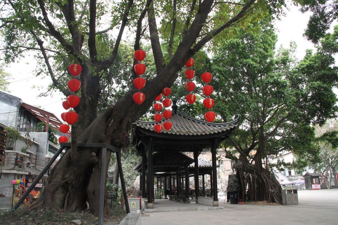 Red Lanterns decorating Chinese style gazebo beside trees