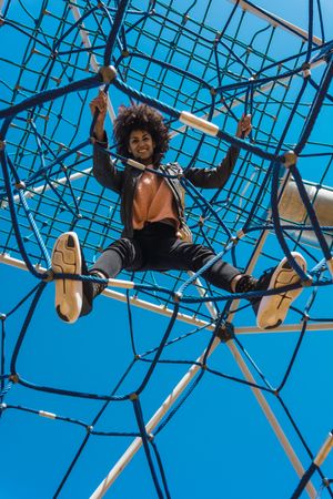 Woman with afro hair climbing by children's attractions.