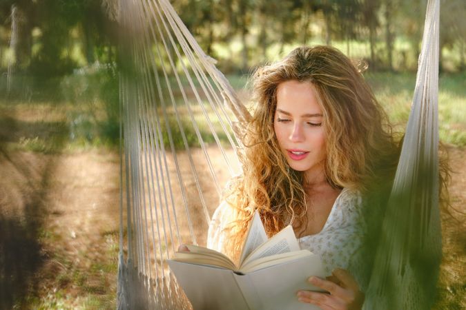 Young female reading book in garden
